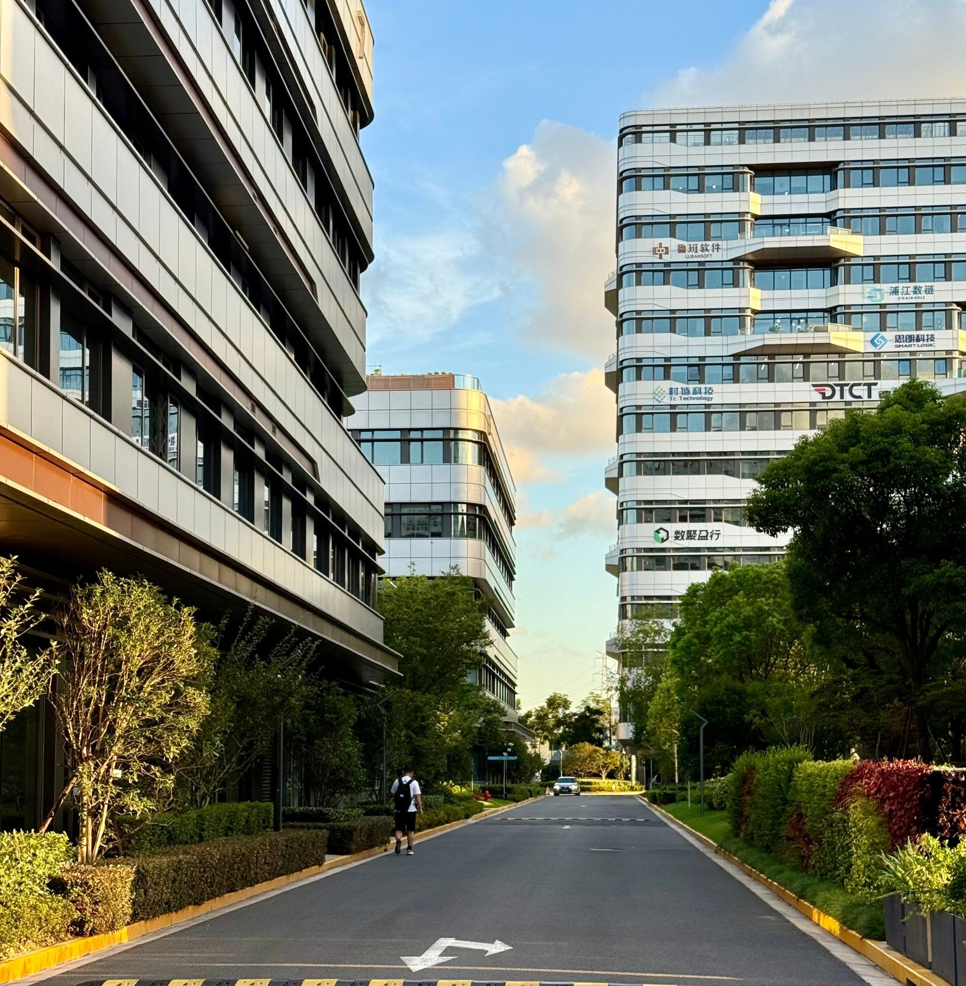 A picturesque street view of modern office buildings surrounded by lush greenery in Shanghai.